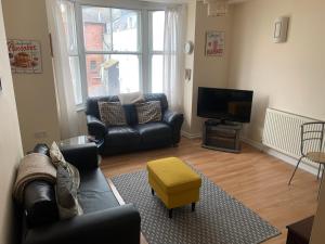 a living room with a couch and a television at Amazing sea views ,brilliant location Apartment in Weymouth