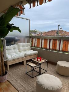 ein Wohnzimmer mit einem Sofa und einem Tisch auf dem Balkon in der Unterkunft Grand 2 pièces à 4mns de la plage in Cagnes-sur-Mer