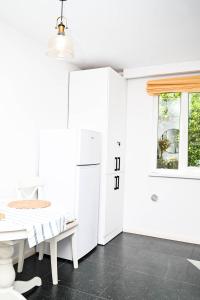a white kitchen with a table and a refrigerator at Dreambed 1 in Baia Mare