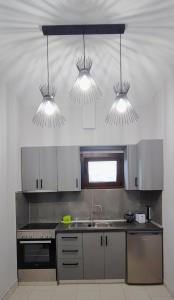 a kitchen with three lights hanging from the ceiling at Mouzakitis Apartments 4 in Arillas