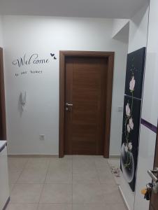 ein Flur mit einer Tür mit einem Schild, das wild liest, kommt in unser Zimmer in der Unterkunft Elena's flat in Kumanovo
