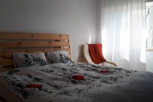 una camera con letto, piumone e sedia di Chilia 3 Apartments a Chilia Veche