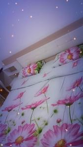a bed with pink flowers on it in a room at Elena's flat in Kumanovo