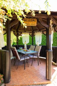 un patio con una mesa y sillas bajo un cenador en Soba i Apartman Đula en Ogulin