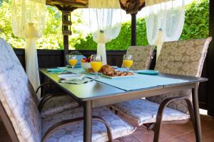 a table with glasses of orange juice and a plate of food at Soba i Apartman Đula in Ogulin