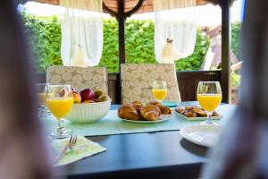 una mesa con un plato de comida y vasos de zumo de naranja en Soba i Apartman Đula en Ogulin