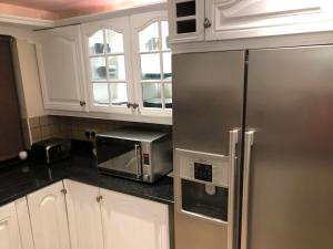 a kitchen with a stainless steel refrigerator and a microwave at Stunning Sea view apartment absolute top quality 100s of 5 star reviews You will not be disappointed in Widows Row