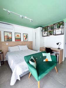 a bedroom with a bed and a green couch at Apartamento para renovar as energias - Cama Queen in Sao Paulo