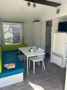 a small room with a table and a table and chairs at Mobile home Grand Confort 30m² Modèle 1 in Arès