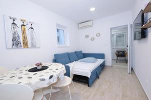 Kleines Zimmer mit einem Bett und einem Tisch in der Unterkunft Apartment Smile in Solin