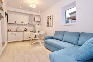 a living room with a blue couch and a kitchen at Apartment Smile in Solin