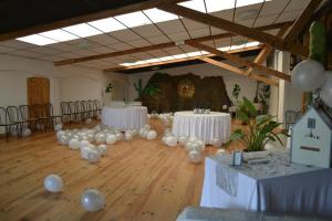 een kamer met witte tafels en witte ballonnen op de vloer bij courfleurie reception in Bousse