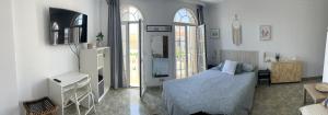 a bedroom with a bed and a desk in it at La casa de Lola in Caleta De Velez