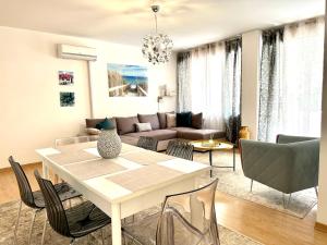 sala de estar con mesa blanca y sillas en Apartament Sabbiadoro Center, en Lignano Sabbiadoro