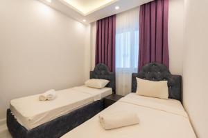 2 camas en una habitación con cortinas rojas en TAYLA SUİT en Kas