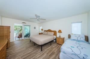 una camera con letto e ventilatore a soffitto di Vista Mar a St Pete Beach