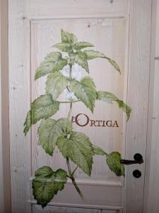 a plant in front of a door with the word orica at Rifugio Cuneck in Velo Veronese