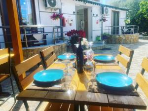 drewniany stół z niebieskimi płytkami i butelkami w obiekcie Vila Reni & Risi w mieście Ksamil