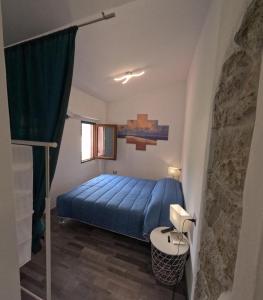 een slaapkamer met een blauw bed in een kamer bij Sole Azzurro Suite in Bosa