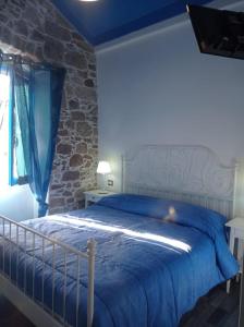 a bedroom with a bed with a blue comforter at Sole Azzurro Suite in Bosa