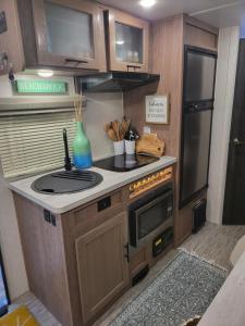 a kitchen with a stove and a sink in a caravan at Island Breeze RV in Covington