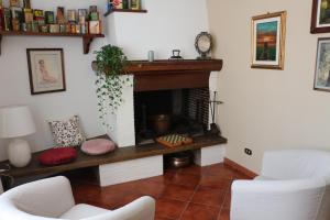 - un salon avec une cheminée et 2 chaises blanches dans l'établissement Casa Marcobando, à Lucques