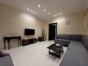 sala de estar con sofá y TV de pantalla plana en لاكازا للشقق المخدومة, en Riad