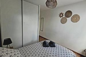 a pair of shoes sitting on a bed in a bedroom at LA NORIA rez de chaussée avec parking en résidence fermée in Aucamville