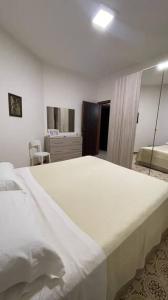 1 dormitorio con 1 cama blanca grande y espejo en Zagara Bianca, en Maiori