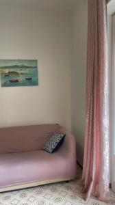 un sofá rosa sentado en una habitación junto a una ventana en Zagara Bianca, en Maiori