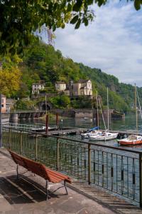 a bench sitting next to a body of water with boats at Casa Vacanza Acqua Dolce in Maccagno Inferiore