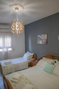卡蘭巴卡的住宿－Villa Nefeli，一间卧室配有两张床和吊灯。