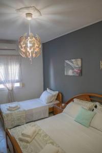 a bedroom with two beds and a chandelier at Villa Nefeli in Kalabaka