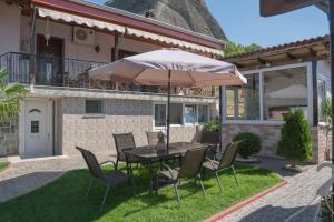 卡蘭巴卡的住宿－Villa Nefeli，院子里的桌椅和雨伞