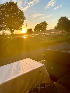 a picnic table with the sunset in the background at House of Happiness mit Seeblick in Hungen