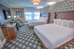 ein Hotelzimmer mit einem großen Bett und einem Schreibtisch in der Unterkunft Q&C Hotel and Bar New Orleans, Autograph Collection in New Orleans
