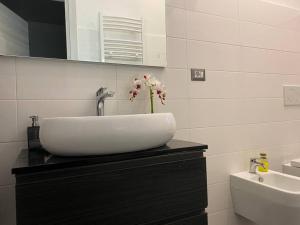 a bathroom with a sink with a flower on a counter at Nel cuore di Alvito, appartamento in centro in Alvito