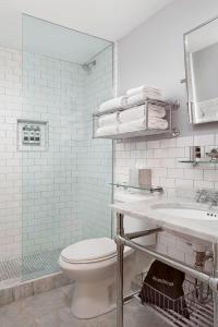 Q&C Hotel and Bar New Orleans, Autograph Collection في نيو أورلينز: حمام ابيض مع مرحاض ومغسلة