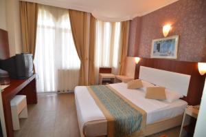 アランヤにあるArtemis Princess Hotelのベッドとテレビが備わるホテルルームです。