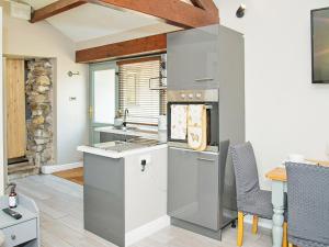 a kitchen with stainless steel appliances and a table at Acre Hill Cottage in Harrop Fold