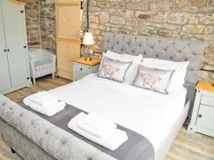 a bedroom with a large bed with towels on it at Acre Hill Cottage in Harrop Fold
