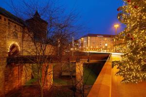 Un árbol de Navidad y un puente en una ciudad por la noche en Le Méridien Grand Hotel Nürnberg, en Núremberg