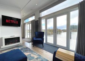 a living room with a chair and a fireplace at Gorgeous Lake Lodge with HTub Outstanding Views in Annan