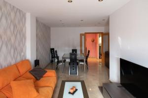 a living room with an orange couch and a table at Apartamento playa Castellón in Grao de Castellón