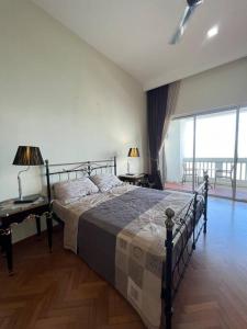a bedroom with a bed and a desk and a window at 2Bedroom Seaview @ Straits Quay in Bagan Jermal