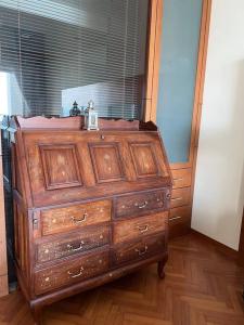 a wooden dresser with a clock on top of it at 2Bedroom Seaview @ Straits Quay in Bagan Jermal