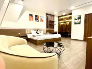 ein Hotelzimmer mit 2 Betten und einem Sofa in der Unterkunft Lucasta Hotel Ha Long in Hạ Long