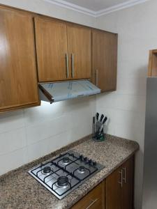 uma cozinha com fogão e armários de madeira em Spacious 3-bedroom apartment em Tétouan