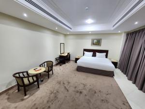 a hotel room with a bed and a table and chairs at S Maskan Hotel in Dammam