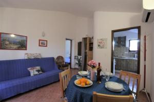 salon z niebieską kanapą i stołem z owocami w obiekcie Apartments Graziella Zambratija w mieście Zambratija